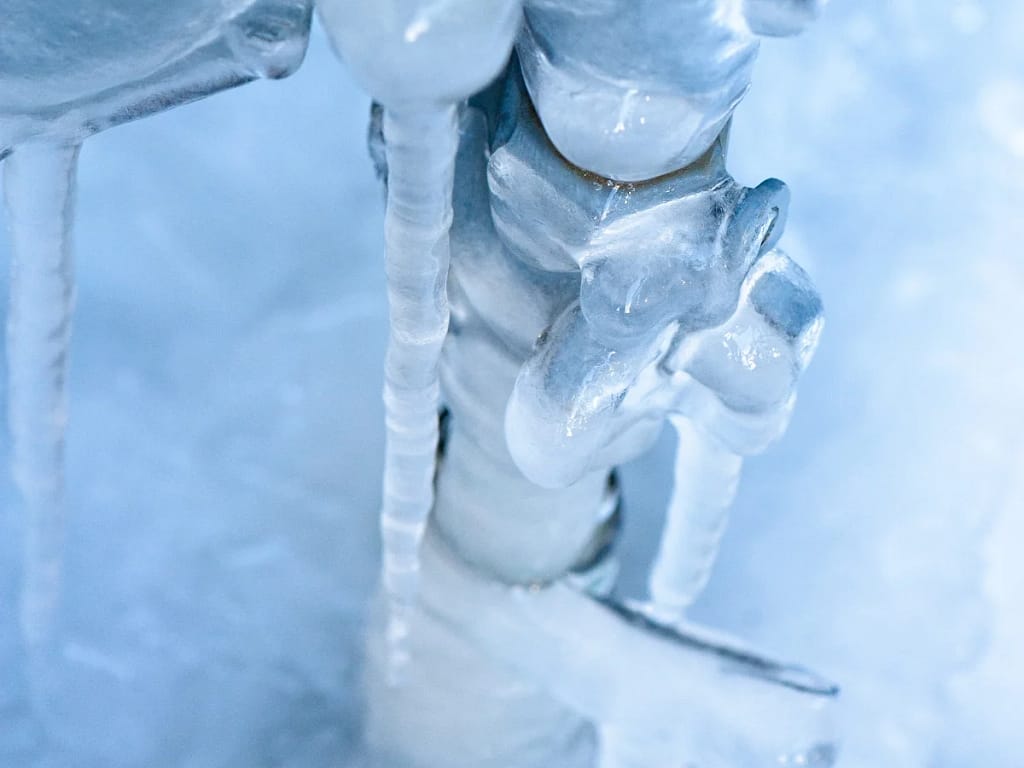 Cautionary image of a water pipe frozen in winter, highlighting the risk of potential bursts and the importance of timely preventive measures.