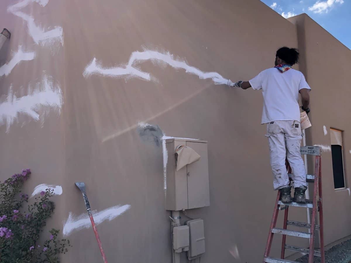 Image of our stucco repair expert meticulously repairing and restoring damaged stucco of a commercial building in tucson, az