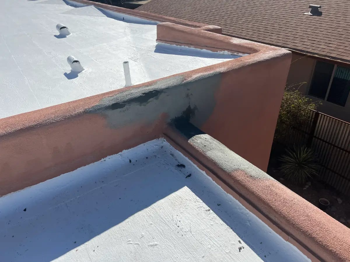 A residential stucco roof parapet in tucson undergoing skilled stucco parapet repair by sunset coatings stucco & paint